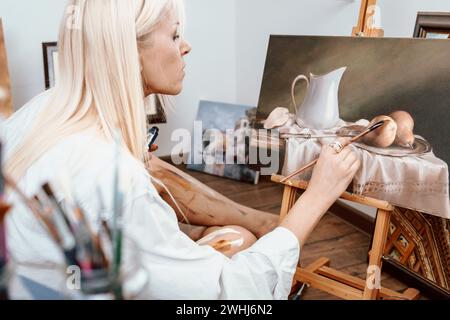 Giovane pittrice bionda nel suo atelier Foto Stock