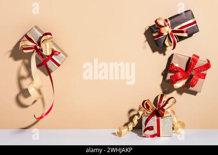 Set di confezioni regalo sullo sfondo del pavimento a parete. Regali confezionati in carta kraft con nastro e fiocco. Concetto di shopping natalizio Foto Stock