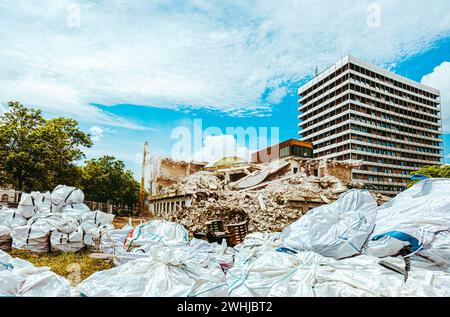 Processo di demolizione di un vecchio edificio smantellato. L'escavatore sta distruggendo la vecchia casa. Foto Stock