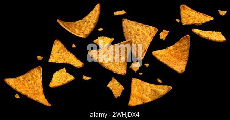 Gocce di mais cadenti, nachos messicani caldi isolati su sfondo nero Foto Stock