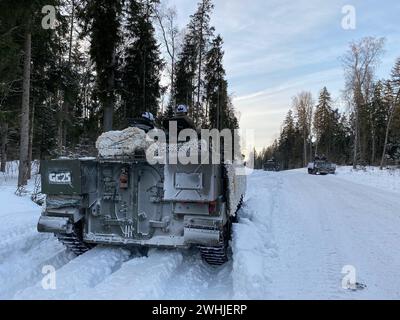 Tapa, Estonia. 10 febbraio 2024. Diversi veicoli militari sono parcheggiati nell'area di addestramento militare ricoperta di neve. Durante un'esercitazione invernale in Estonia, le truppe della NATO si stanno addestrando per proteggere e difendere il fianco orientale della NATO nelle fredde condizioni invernali. Anche le forze armate di Francia e Gran Bretagna partecipano alla prima esercitazione, che va dal 15 febbraio fino alla fine dell'anno. Crediti: Alexander Welscher/dpa/Alamy Live News Foto Stock