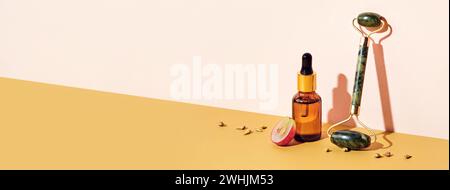 Striscione con cosmetici biologici a base di olio di semi d'uva e rullo massaggiante. Nessun rifiuto di vinificazione. Prodotto cosmetico per la cura della pelle, isom diagonale Foto Stock