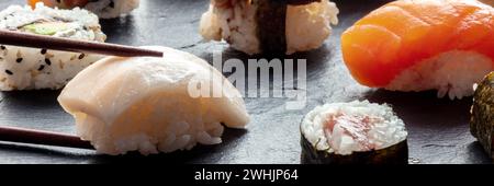 Sushi con panorama con bacchette. Nigiri Whitefish su sfondo nero Foto Stock