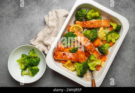 Vista dall'alto di bistecche di salmone al forno, broccoli, cavolfiore, carote in casseruola. Cucinare un delizioso dinn basso carb Foto Stock
