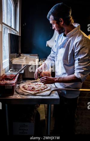 Chef che prepara pizza artigianale. King's Road Yard Street Market, Pontcanna, Cardiff. Mercato agricolo. La pizza di Tom. Cibo artigianale. Foto Stock