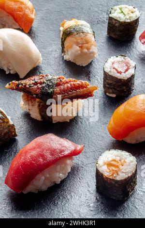 Assortimento di sushi. Maki e nigiri su sfondo nero, cibo giapponese Foto Stock