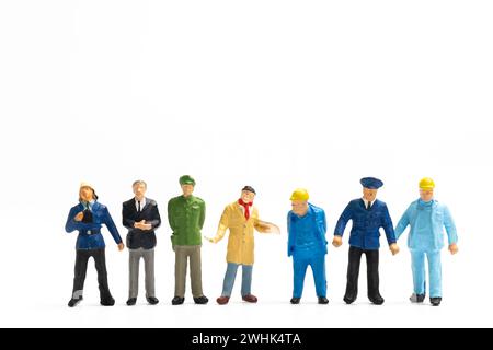 Persone in miniatura diverse professioni in piedi su sfondo bianco, concetto di giornata del lavoro Foto Stock