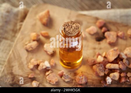 Una bottiglia trasparente di olio essenziale per aromaterapia con resina styrax benzoina Foto Stock