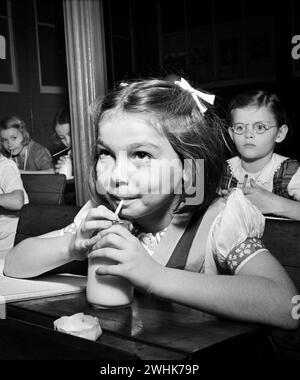 Ragazza che beve un bicchiere di latte in classe, New York, New York, USA, Marjory Collins, U.S. Office of War Information, ottobre 1942 Foto Stock