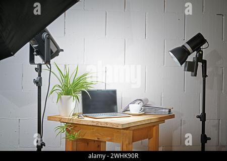 Piccolo studio fotografico da tavolo in un garage con una tavola di legno per gli oggetti, le luci e gli stand, concetto per il business creativo a Foto Stock