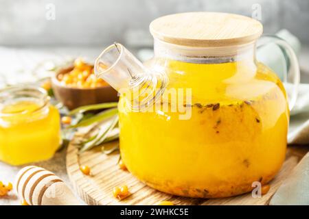 Mare sano â€‹â€‹â€‹â€‹tè con miele su fondo di pietra grigia. Tè autunnale, bevanda di stagione alle bacche. Foto Stock