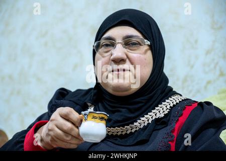 Donna che beve caffè con la faccia sorridente Foto Stock