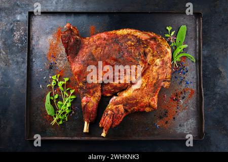 Tradizionale barbeque metà di capra da latte con spalle e gamba servito come vista dall'alto su un vassoio nero rustico Foto Stock