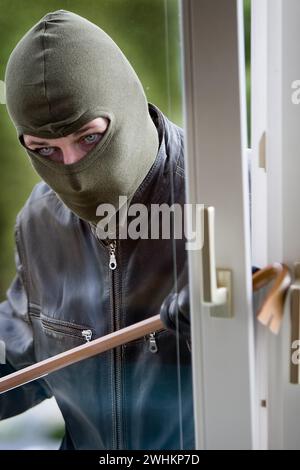 Un ladro con un palanchino a una finestra Foto Stock