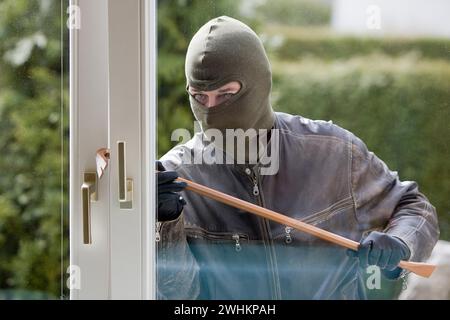 Un ladro con un palanchino a una finestra Foto Stock