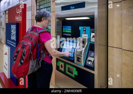 Immagine interna, donna anziana, migliore scelta al distributore automatico di biglietti, terminal dei biglietti, stazione al Ras, stazione ferroviaria, metropolitana di Dubai, RTA, Dubai Creek, traffico Foto Stock