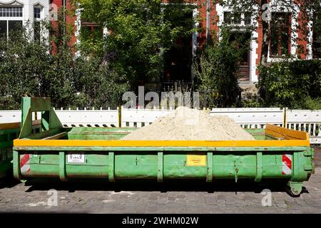 Container, salta per costruire macerie sulla strada, cantiere, barriera, lavori stradali, strada residenziale con vecchie case, Brema, Germania Foto Stock