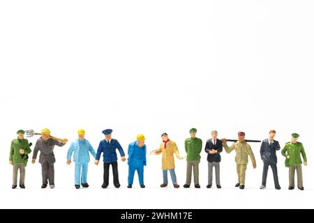 Persone in miniatura diverse professioni in piedi su sfondo bianco, concetto di giornata del lavoro Foto Stock