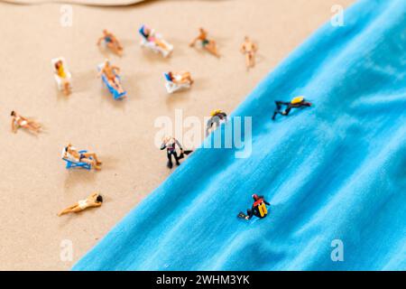 Una piccola persona con una tuta da immersione sulla spiaggia in estate Foto Stock