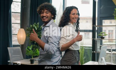 Entusiasti colleghi multirazziali partner commerciali uomo d'affari indiano arabo e donna ispanica colleghi d'affari che guardano alla telecamera felice Foto Stock
