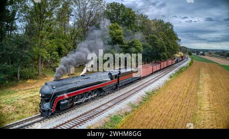 Vista aerea bassa di un treno a vapore d'epoca, fumo nero soffiante e vapore Foto Stock