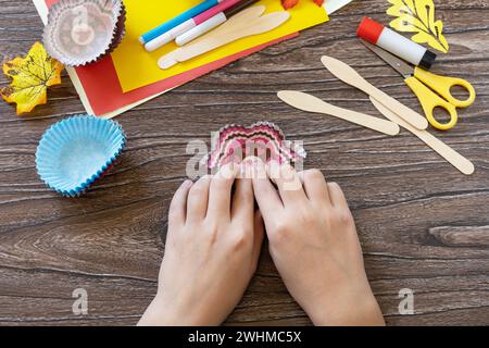 Istruzioni, fase 2. Giocattoli del Ringraziamento, burattini di tacchino su un tavolo di legno. Fatto a mano. Progetto di creatività per bambini, handicr Foto Stock