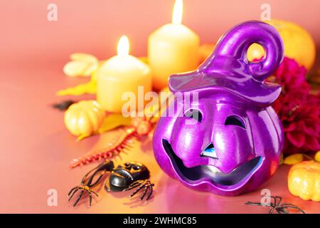 Il concept creativo di halloween. Jack o lanterna viola di Halloween con candele accese, zucche su sfondo marrone chiaro. Foto Stock