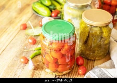 Cetrioli sottaceto salati e pomodori conservati in scatola in vaso di vetro. Economia domestica, conservazione del raccolto autunnale. Omema sano Foto Stock