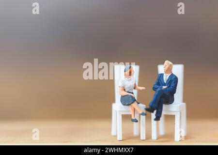 Persone in miniatura che pensano alla prossima grande idea su sfondo di legno Foto Stock