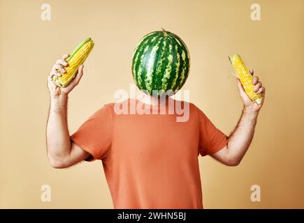 Uomo divertente con anguria invece di testa che tiene il mais. Collage di arte concettuale e contemporanea. Foto Stock