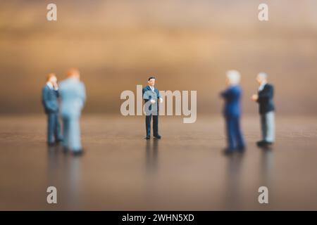 Uomo d'affari in miniatura su sfondo in legno Foto Stock