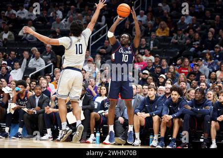 Washington DC, Stati Uniti. 10 febbraio 2024. La guardia Hassan Diarra (10) del Connecticut Huskies colpisce Georgetown Hoyas, la guardia Jayden Epps (10) durante un match tra Georgetown Hoyas e Connecticut Huskies alla Capital One Arena di Washington DC. Daniel Kucin Jr./Cal Sport Media/Alamy Live News Foto Stock
