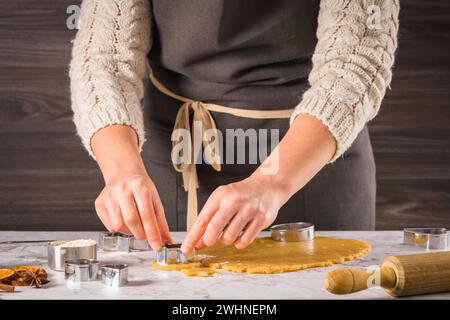 Mani femminili che preparano biscotti di Natale Foto Stock