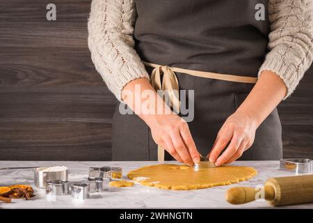 Mani femminili che preparano biscotti di Natale Foto Stock