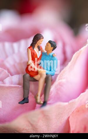 Miniature People Young girl seduto sul suo grembo di ragazzo Foto Stock