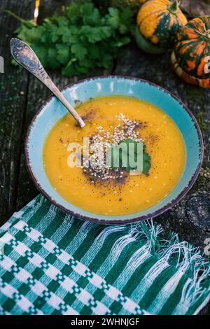 Zuppa di zucca su piatto autunnale in legno Foto Stock