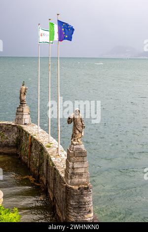 Antiche statue si affacciano sulla Villa del Balbianello, sul Lago di Como in una giornata ventosa a Lenno, in Lombardia, in Italia. Foto Stock