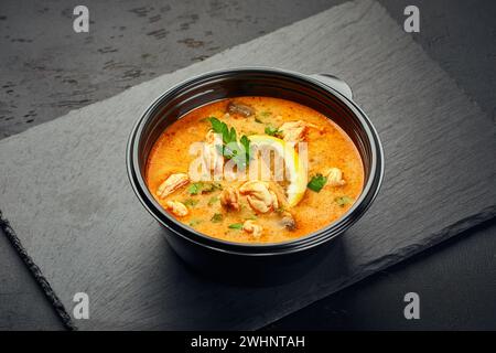 Tradizionale zuppa tailandese Tom Yam in una ciotola di plastica Foto Stock