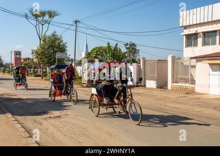 Tradizionale risciò sulle strade della città di Antsirabe. I risciò sono un mezzo di trasporto comune in Madagascar. Foto Stock