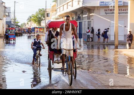 Bicicletta tradizionale risciò con gente malgascia sulla strada di Toliara, uno dei modi per guadagnare soldi. La vita quotidiana sul Foto Stock