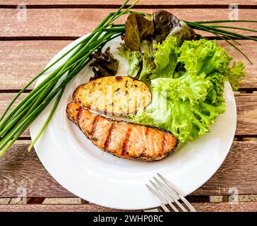 Filetto di salmone alla griglia con patate e insalata Foto Stock