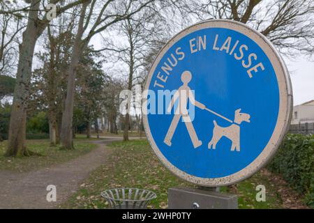 Si prega di tenere il vostro cane su un cartello con le informazioni di piombo in francese significa france chien tenus en laisse per proteggere la fauna selvatica e altre persone che camminano nell'aria Foto Stock