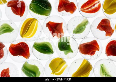 Sfere in vetro trasparente con design multicolore astratto all'interno su sfondo bianco con retroilluminazione Foto Stock
