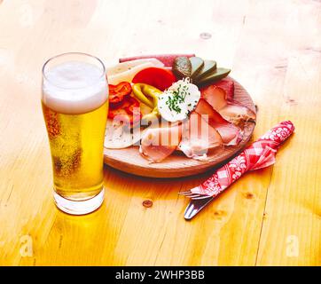 Cibo tirolese con salsiccia, formaggio, pancetta e birra leggera Foto Stock