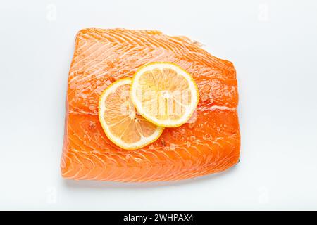 Filetto di salmone marmorizzato crudo fresco isolato su sfondo bianco con limone e sale grossolano, vista dall'alto. Nutrizione e dieta sana Foto Stock