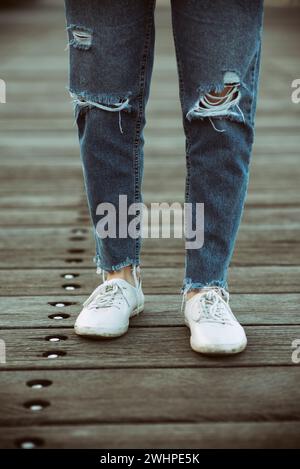 Primo piano delle gambe della donna in jeans all'aperto Foto Stock