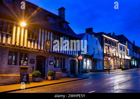 Burford House e negozi lungo la strada principale di Burford all'alba. Cotswolds, Oxfordshire, Inghilterra Foto Stock