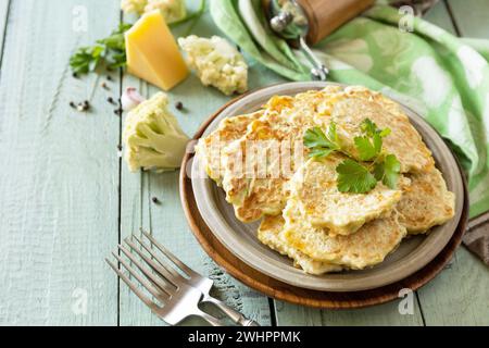 Cotolette vegetariane fritte o frittelle. Frittelle di verdure al cavolfiore con formaggio su un tavolo da cucina rustico. Copia spazio. Foto Stock