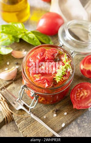 Cibo fermentato sano fatto in casa. Pomodori secchi in vaso con spezie ed erbe aromatiche. Economia domestica, conservazione del raccolto autunnale. Foto Stock