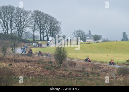 Balfron, Stirling, Scozia, Regno Unito. 11 febbraio 2024. Raccolta fondi Trossachs Tractor Run per Chest Heart e Stroke Scotland. L'evento di beneficenza è stato organizzato da Robert Wilson di Kippen in memoria del famoso fabbro Arnprior Bobby Gunn che morì improvvisamente al lavoro nel 2017. Oltre 40 trattori percorreranno il percorso di 50 km attraverso l'area di Stirling. Le donazioni all'ente di beneficenza possono essere fatte attraverso la pagina "Just Giving" di Robert. Crediti: Kay Roxby/Alamy Live News Foto Stock